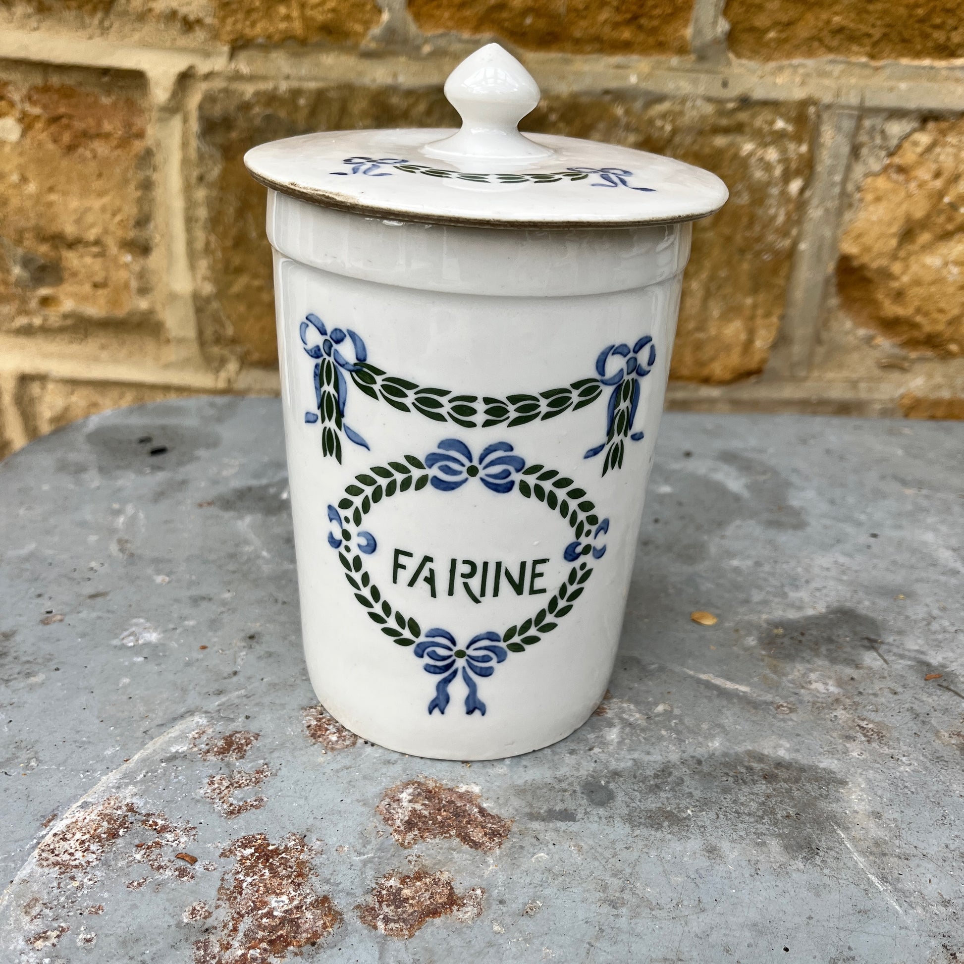 Set of ceramic storage jars with French text and decorative elements