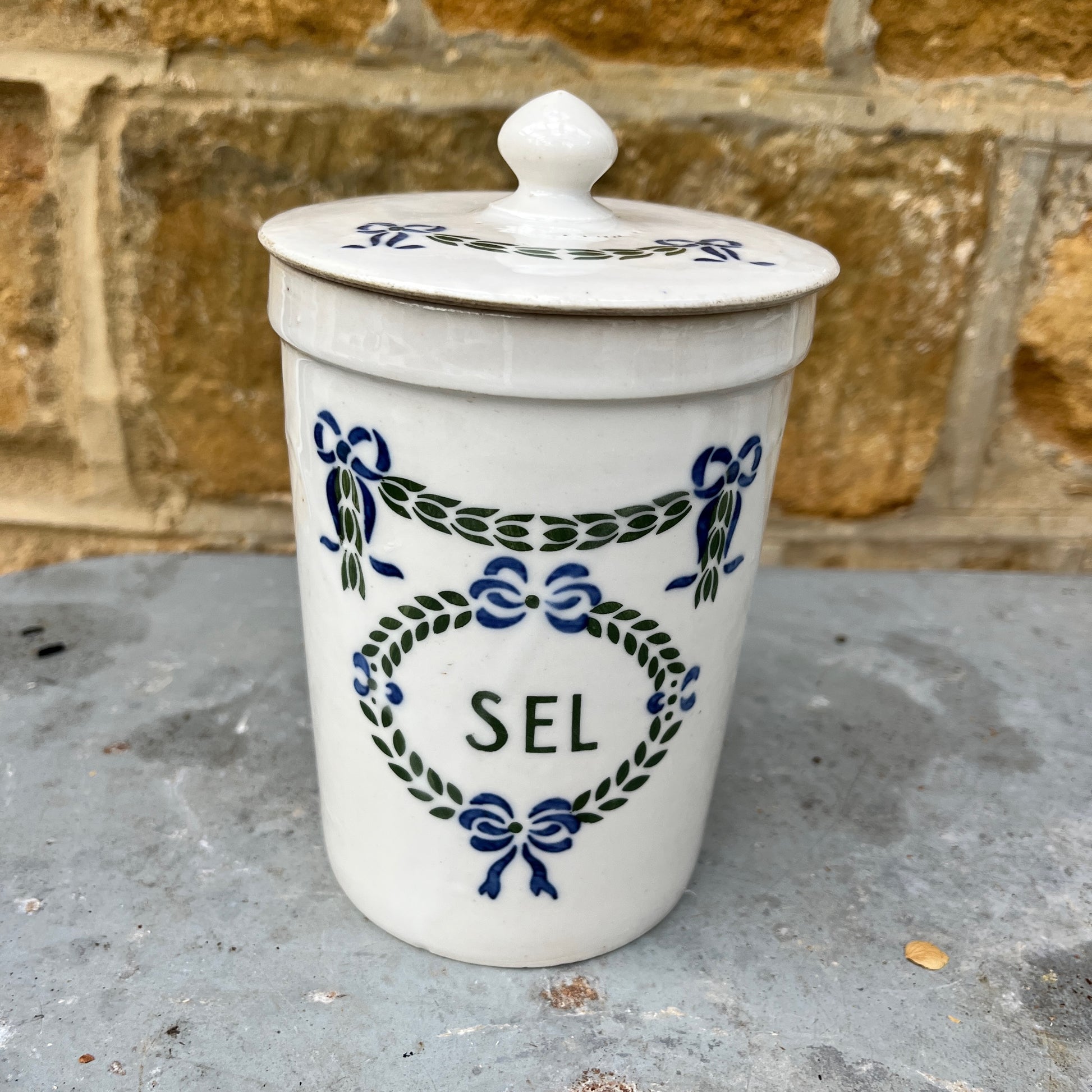 Set of ceramic storage jars with French text and decorative elements