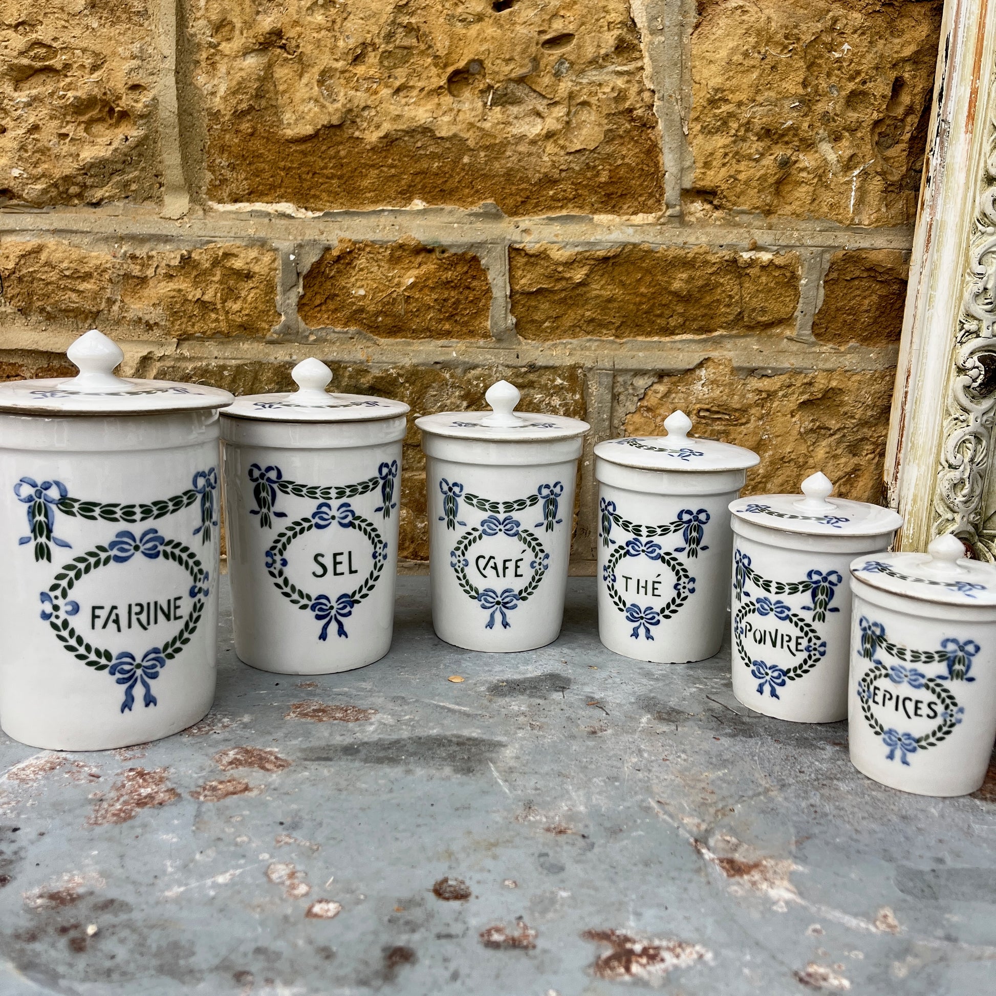 Set of ceramic storage jars with French text and decorative elements