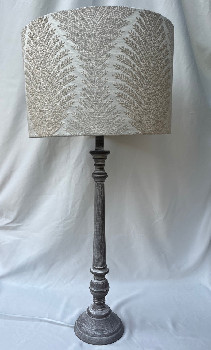 Large cream leaf pattern lampshade upon a tall base -suzie-catlin-designs