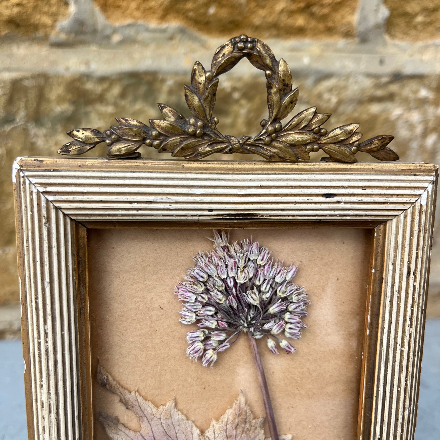 Decorative French frame with a dried flowers and gold wreath on a textured background