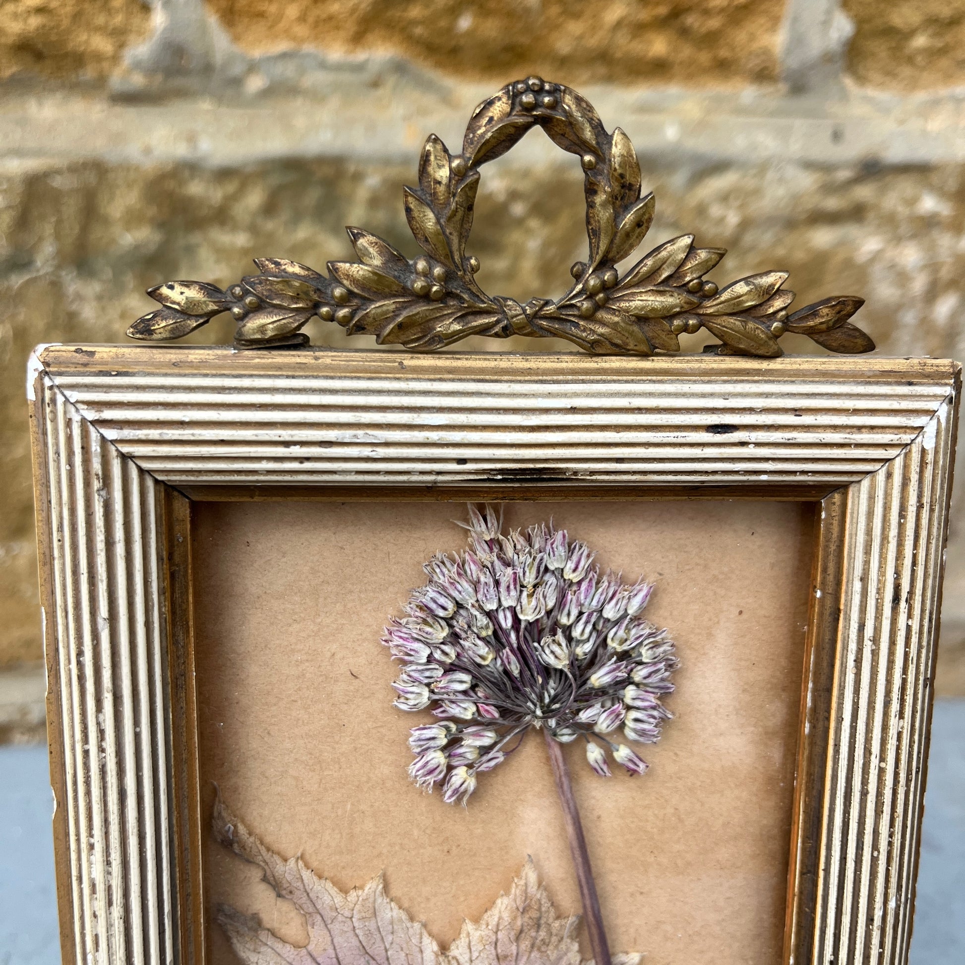 Decorative French frame with a dried flowers and gold wreath on a textured background