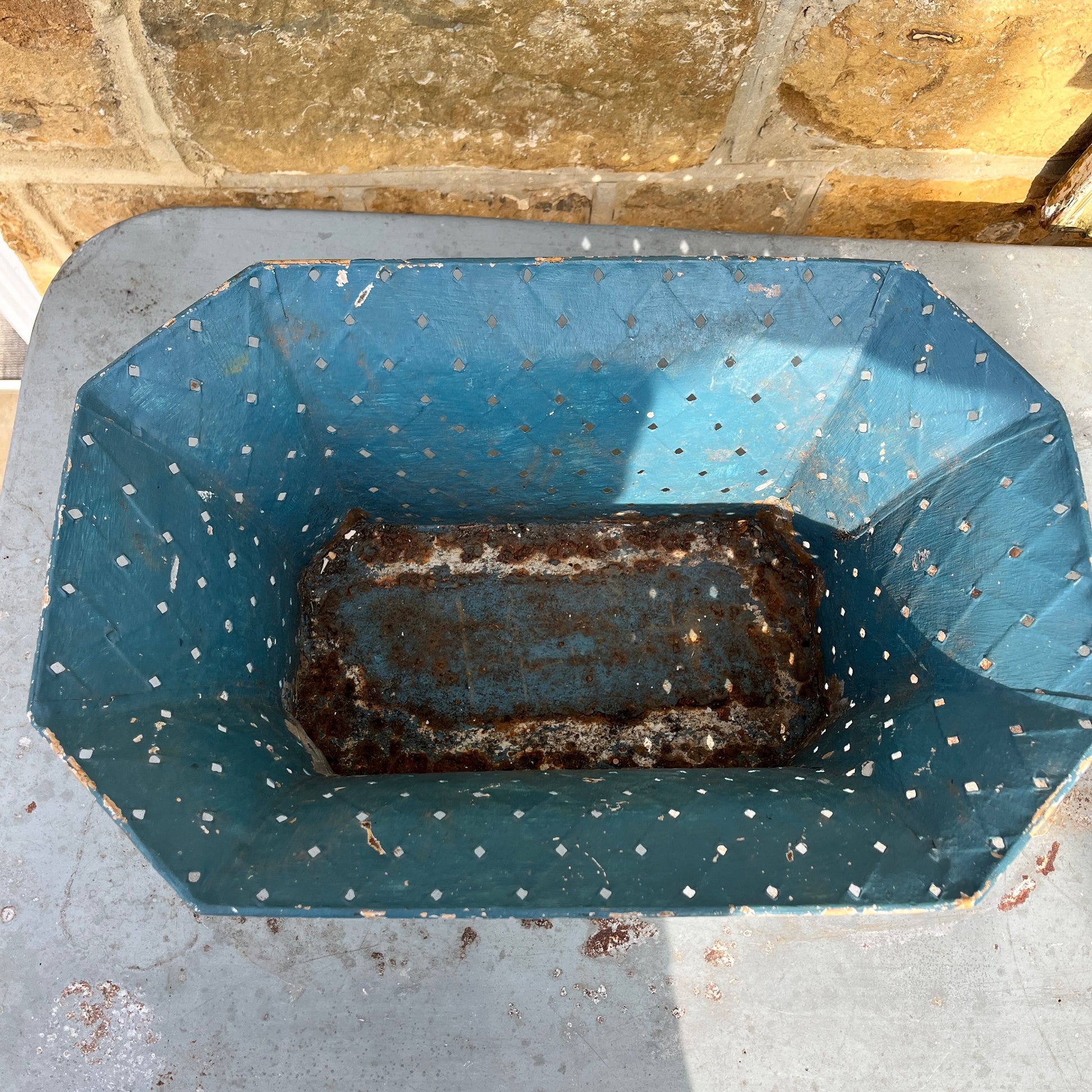 A large, vintage French jardinière in blue metal.  It has a shabby chic aesthetic with visible chips, wear, and some rust on the enamel, adding to its antique charm. Perfect for French country or vintage decor