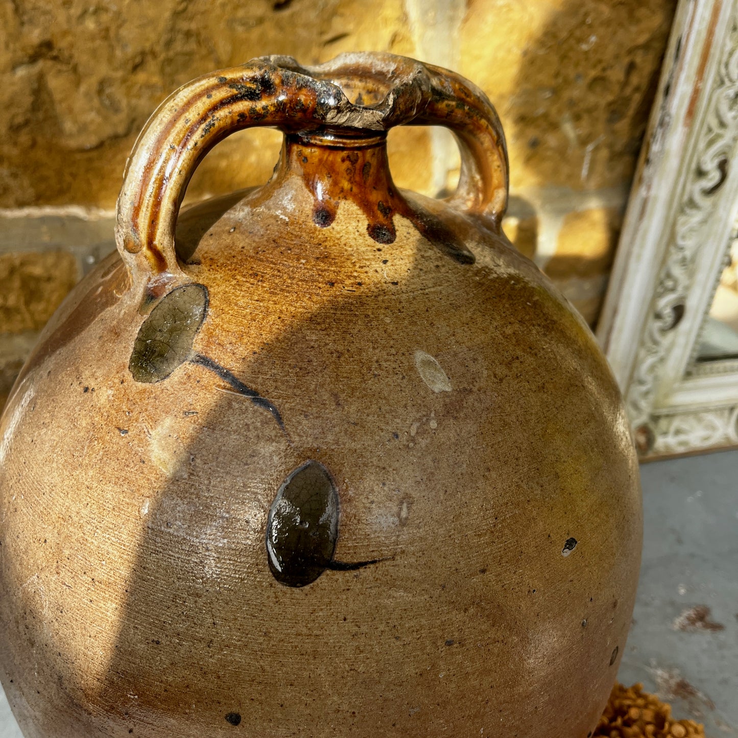 Large vintage French stoneware oil jar with a rounded body, narrow neck, and earthy glaze, showing natural patina and rustic texture typical of traditional French farmhouse pottery.