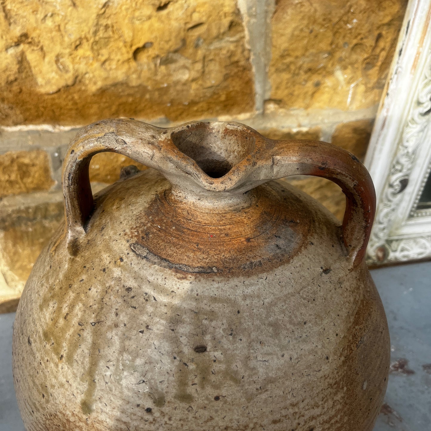 Large vintage French stoneware oil jar with a rounded body, narrow neck, and earthy glaze, showing natural patina and rustic texture typical of traditional French farmhouse pottery.