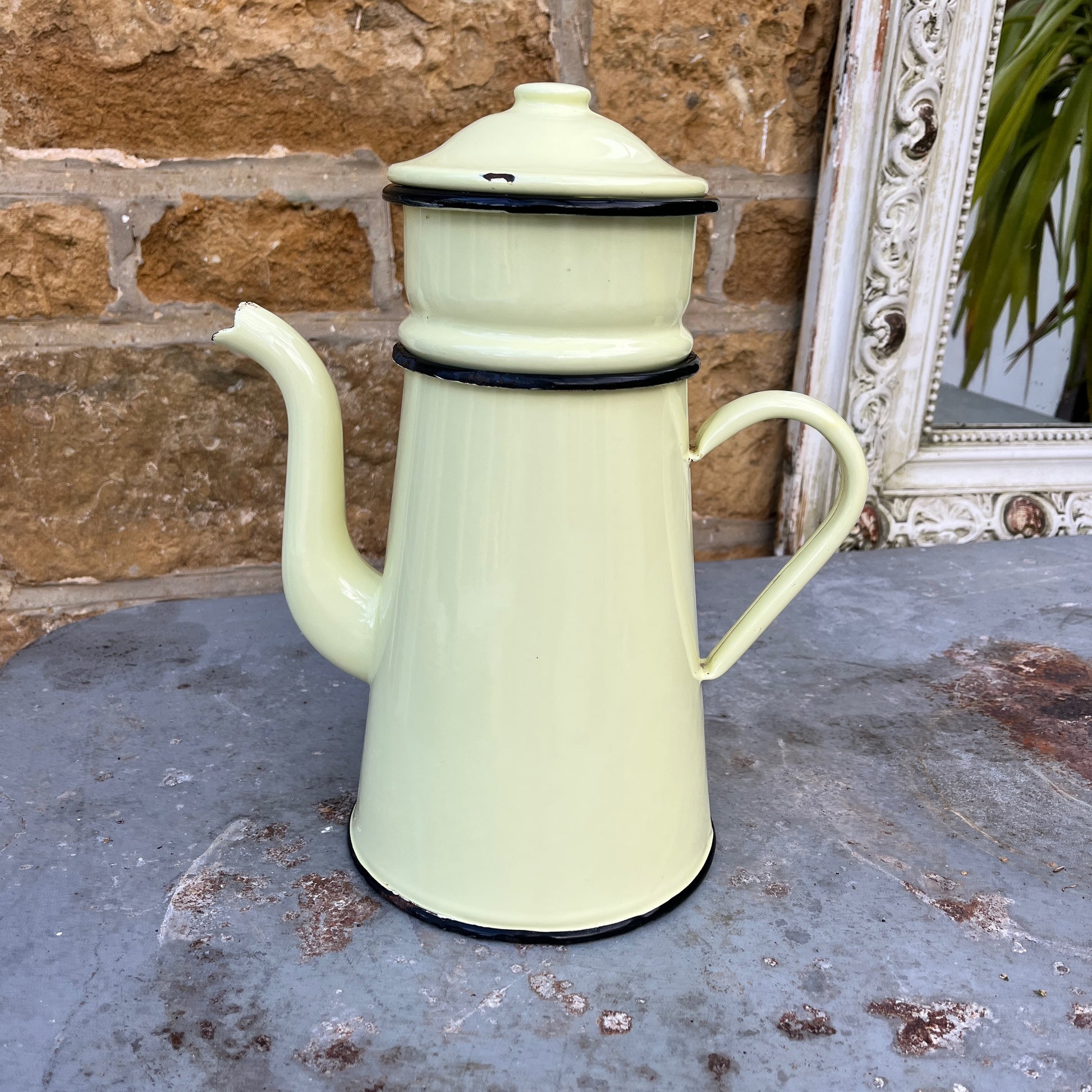 A vintage French yellow enamel coffee pot, circa 1920s, with a soft yellow body and black trim. It includes all four brewing pieces, showing minor chips and rust that add to its authentic patina