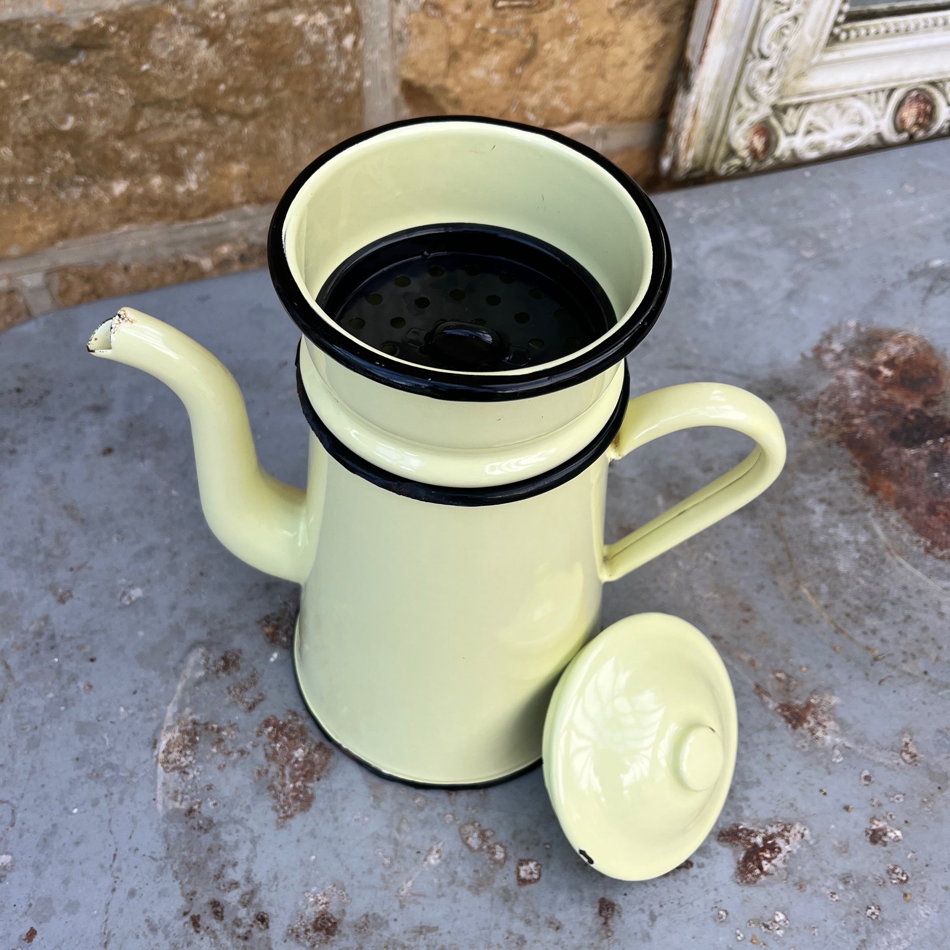 A vintage French yellow enamel coffee pot, circa 1920s, with a soft yellow body and black trim. It includes all four brewing pieces, showing minor chips and rust that add to its authentic patina