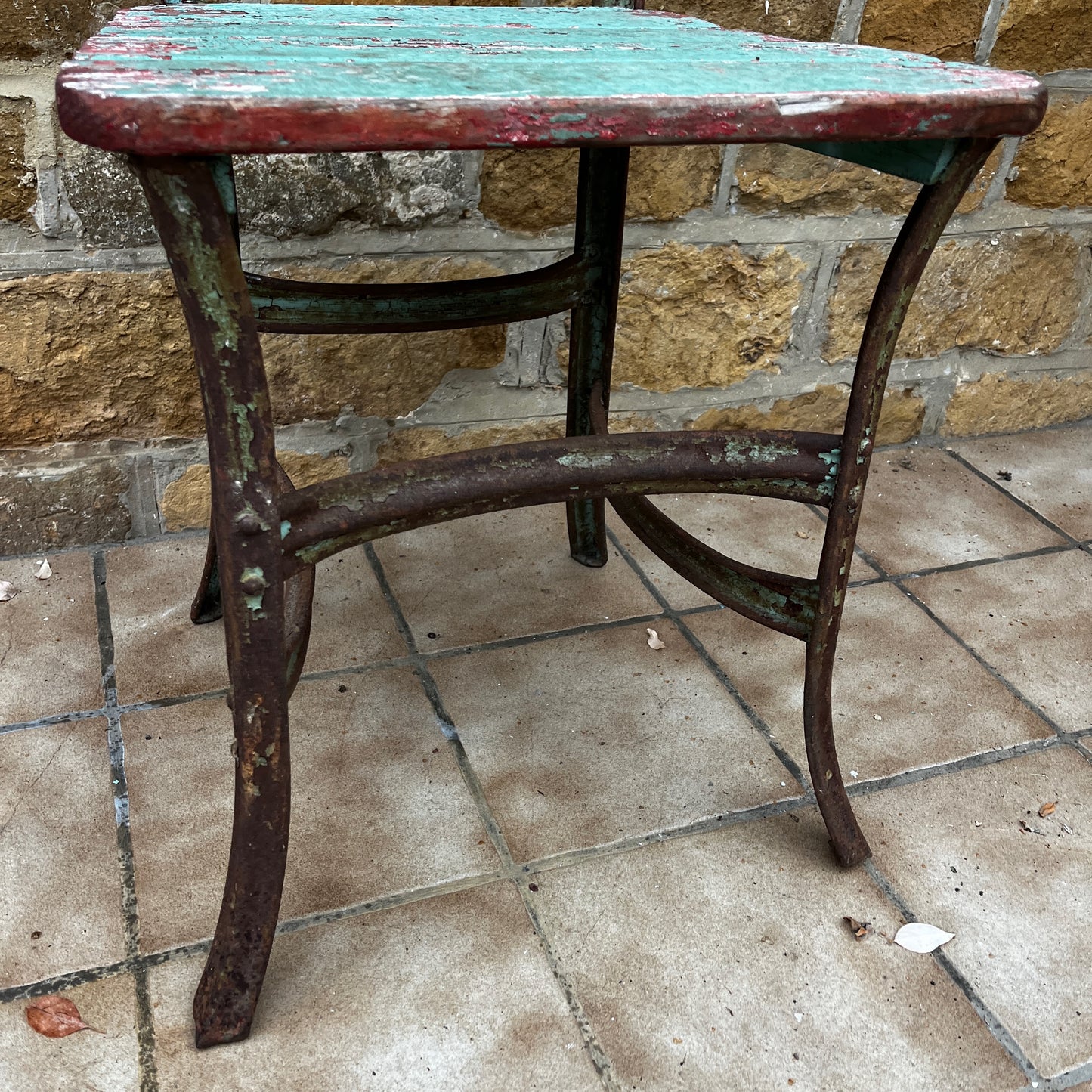 Pair of antique garden chairs made of wood and metal, painted in a soft green color. The chairs show signs of age and wear, highlighting their vintage charm and rustic, outdoor appeal.