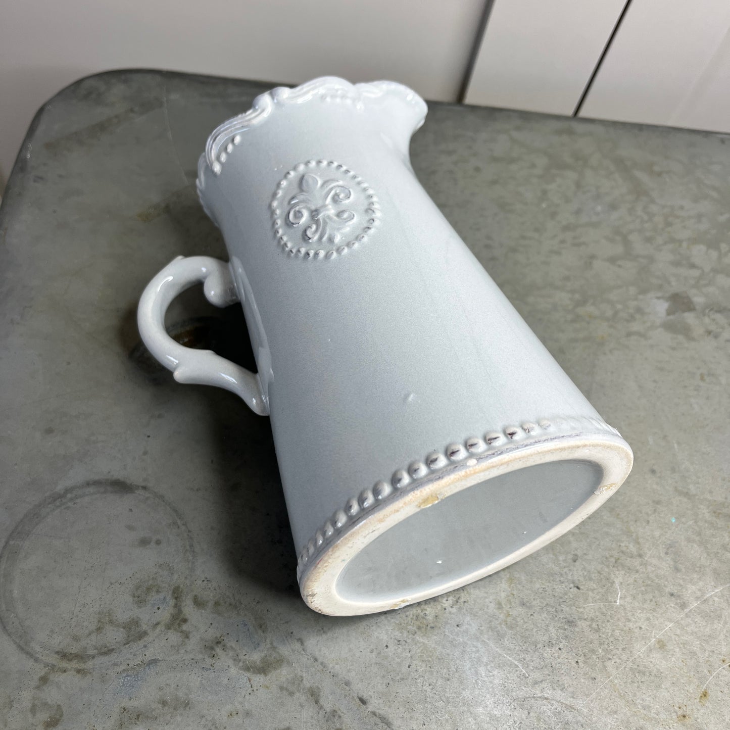 Gray ceramic mug with decorative patterns on a concrete surface