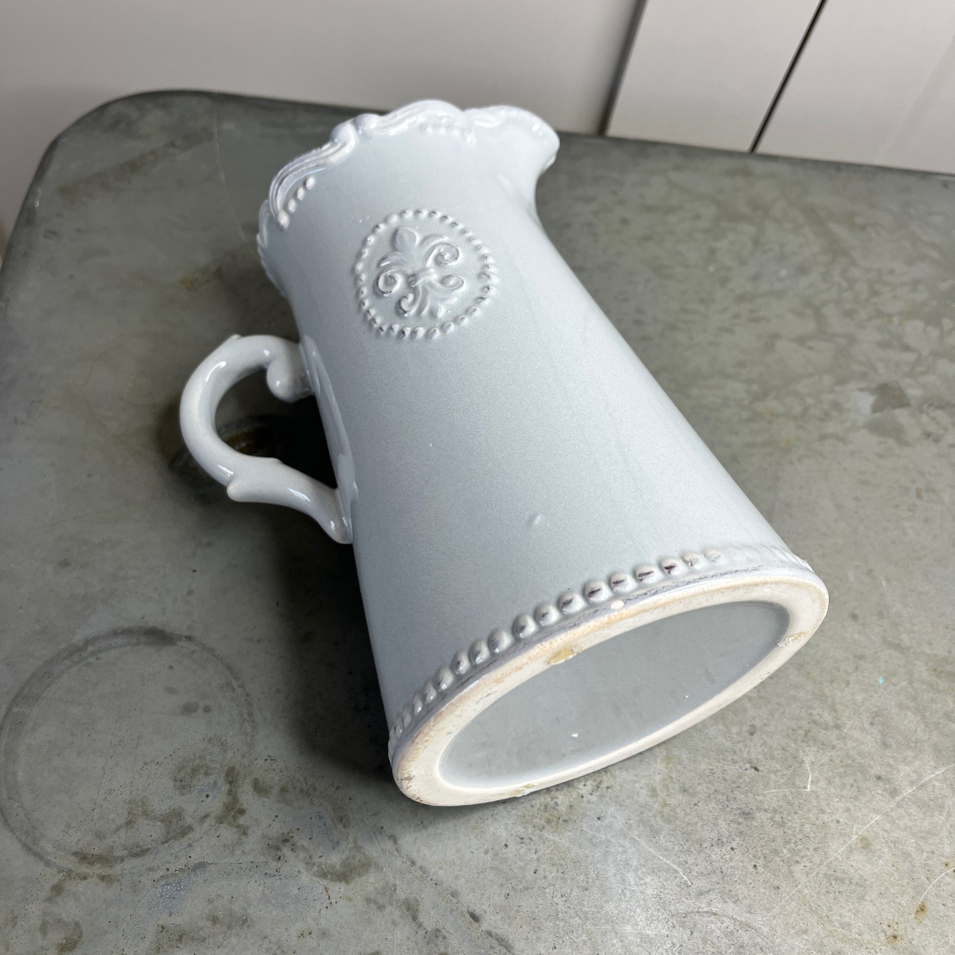 Gray ceramic mug with decorative patterns on a concrete surface