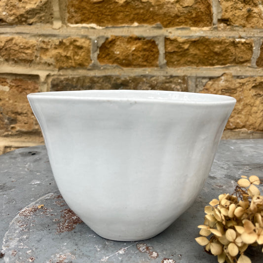 A vintage ceramic white jelly mould with a smooth, glossy finish, featuring a classic fluted design and an oval shape