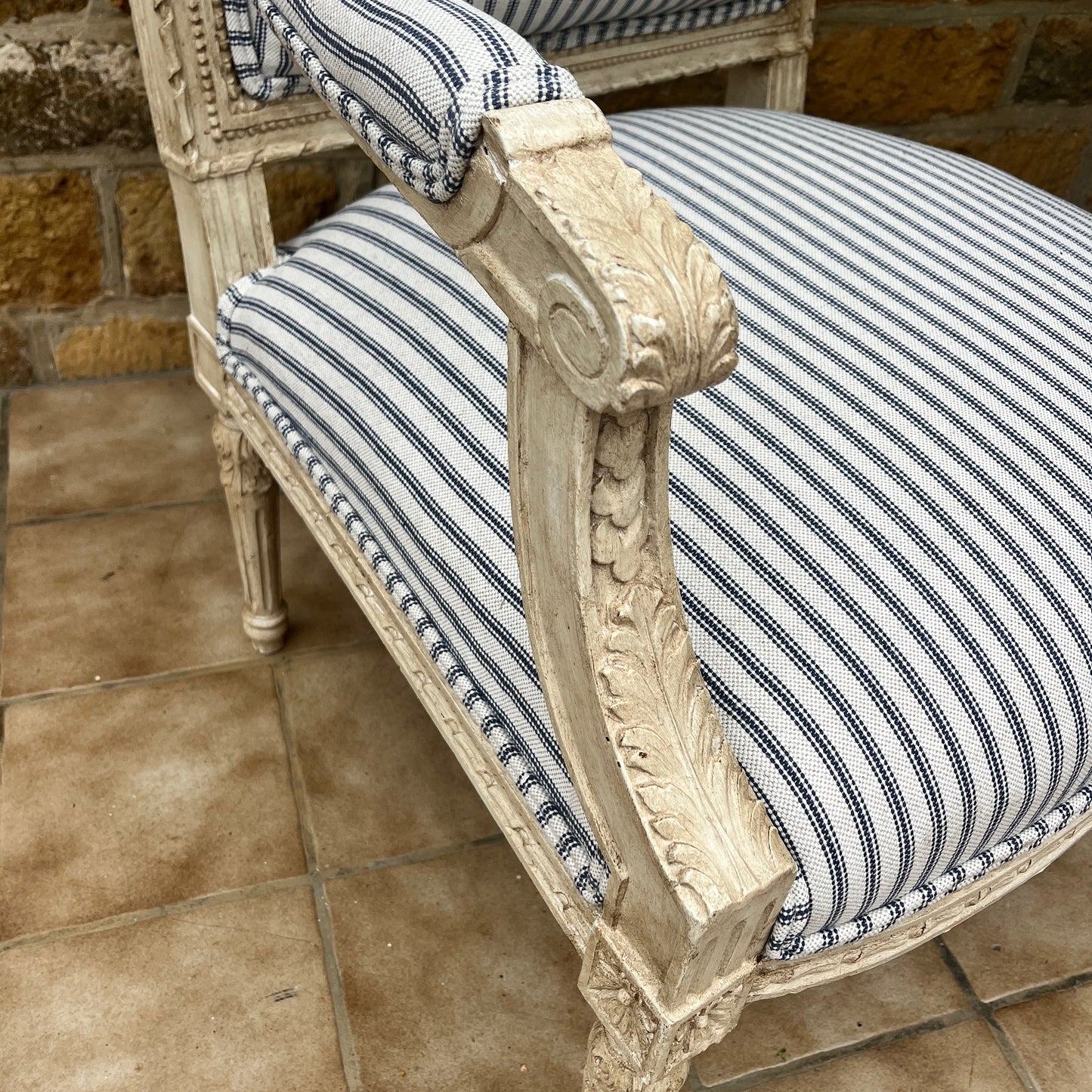 Louis Philippe-style antique chair with a curved wooden frame, featuring newly upholstered blue and white ticking fabric on the seat and backrest.