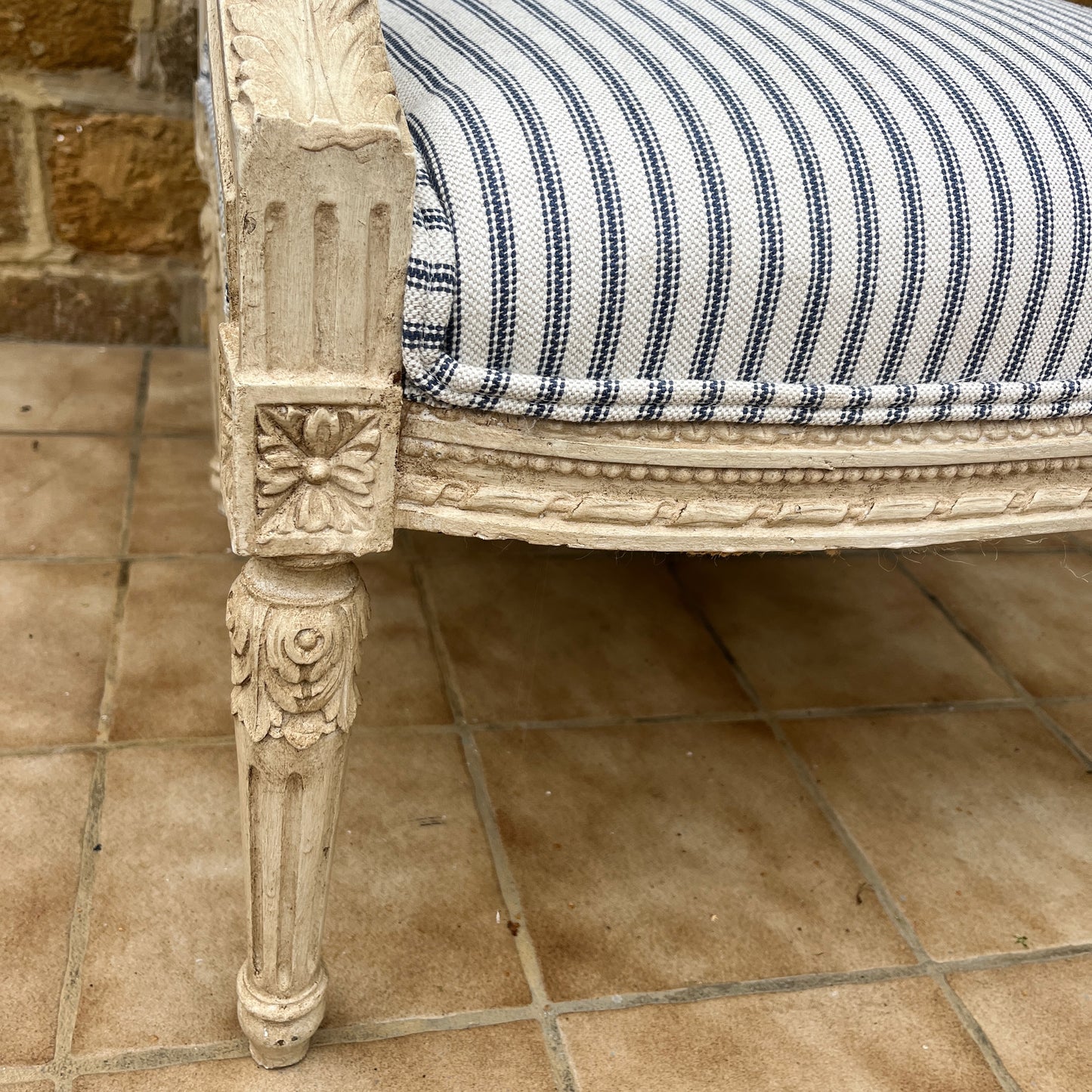 Louis Philippe-style antique chair with a curved wooden frame, featuring newly upholstered blue and white ticking fabric on the seat and backrest.