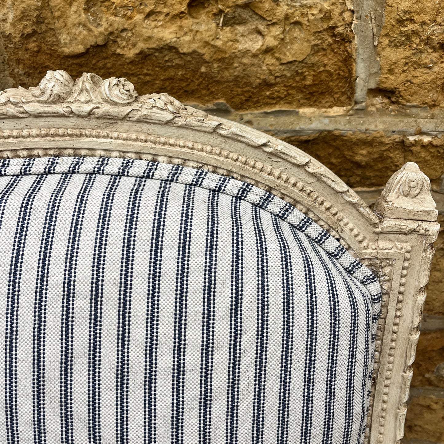 Louis Philippe-style antique chair with a curved wooden frame, featuring newly upholstered blue and white ticking fabric on the seat and backrest.