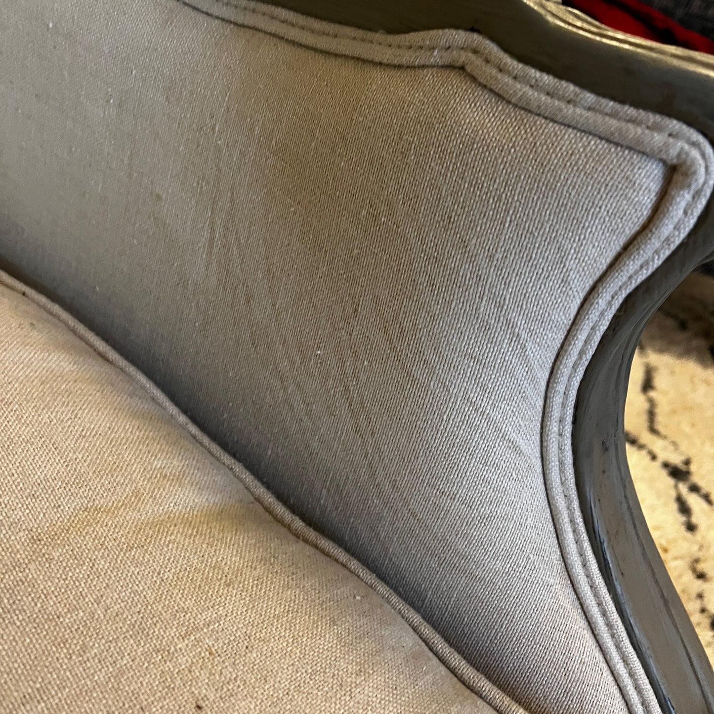 New French-style armchair with a carved wooden frame and linen upholstery, featuring a relaxed elegant silhouette and neutral fabric finish.