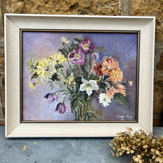An oil on canvas painting by Mary Hogg, showcasing a vibrant arrangement of flowers with bold brushstrokes in shades of purple, yellow, orange and green. The floral composition, set against a soft, blurred background, exudes a lively, impressionistic charm