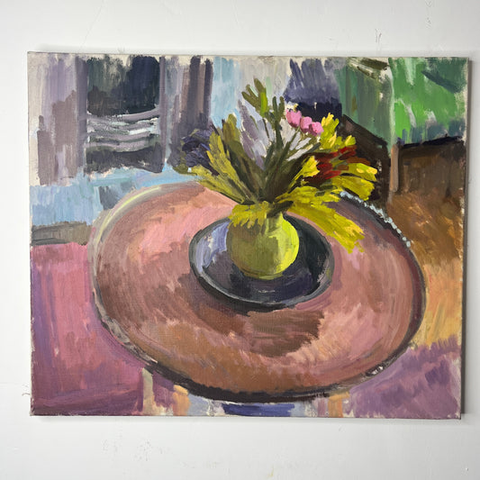 An oil-on-canvas still life painting capturing a serene living room scene, featuring a bouquet of pink tulips gracefully arranged in a green vase on a wooden table. In the room is a green armchair, and fire place, evoking a sense of quiet elegance. and coziness.
