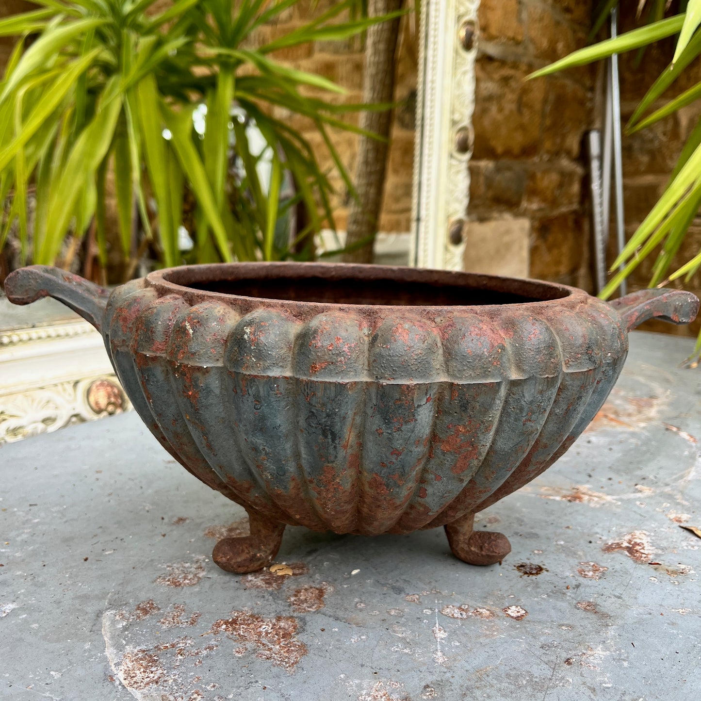 A round French jardinière crafted from metal. The planter has a classic, slightly weathered finish, with subtle decorative accents, exuding rustic French elegance