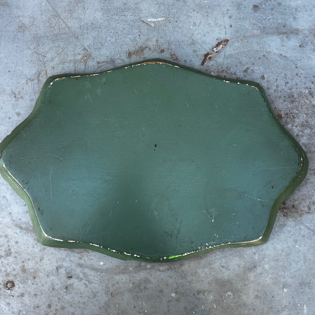 An antique oval tray featuring a painted floral bouquet in the center and a scalloped gold frame