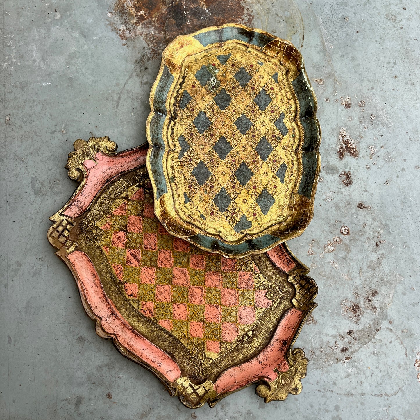 Decorative pink and gold florentine tray with a checkered pattern on a textured gray background