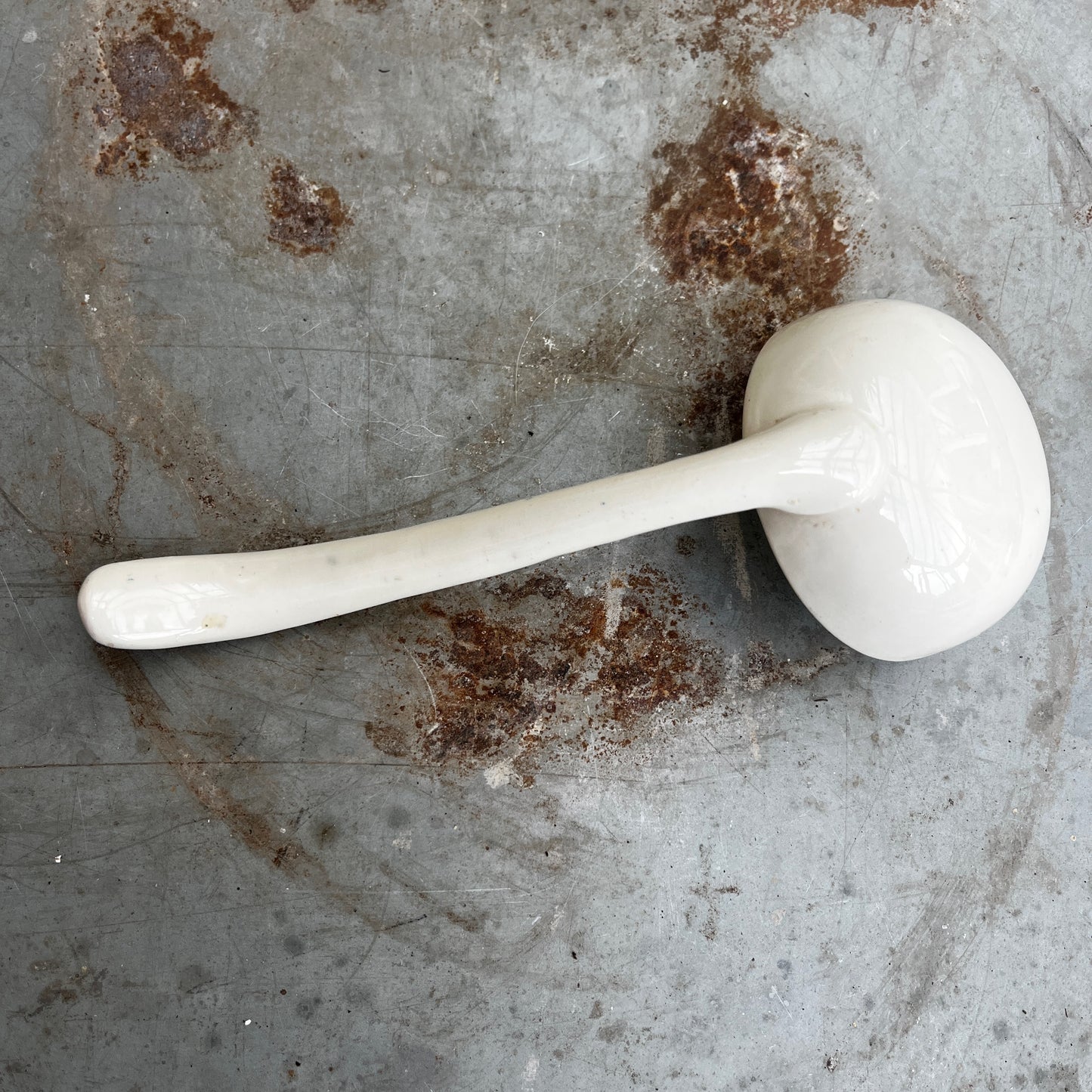 19th-century English transferware ceramic sauce ladle with traditional decorative patterning and a curved handle