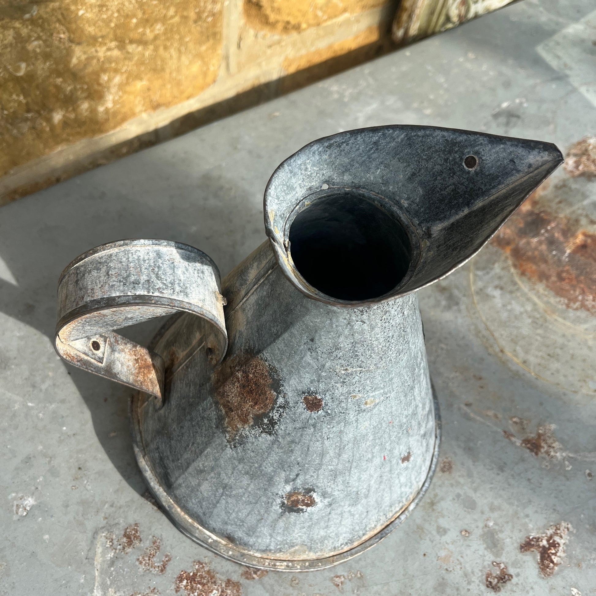 Rust-covered metal jug with large funnel