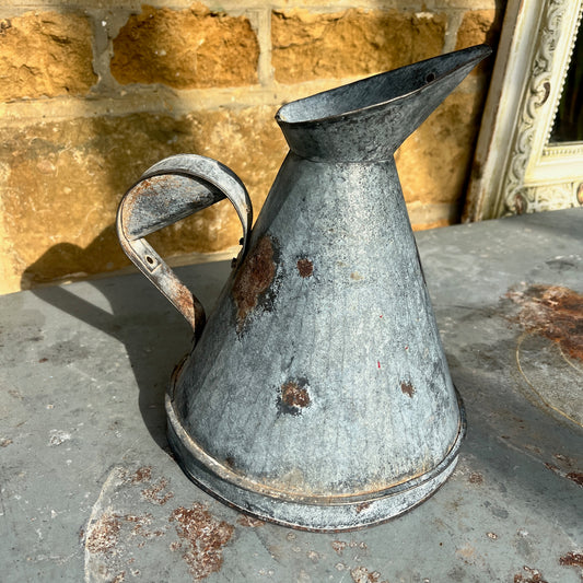 Rust-covered metal jug with large funnel