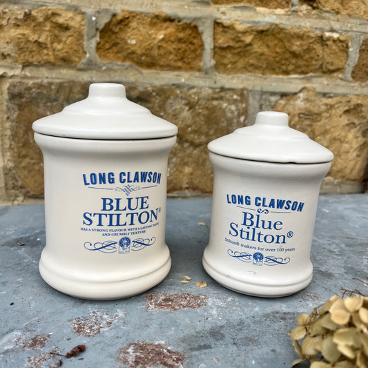 A pair of ceramic jars, each with a fitted lid featuring a classic design, labeled Blue Stilton cheese. The jars have a vintage, sturdy look.