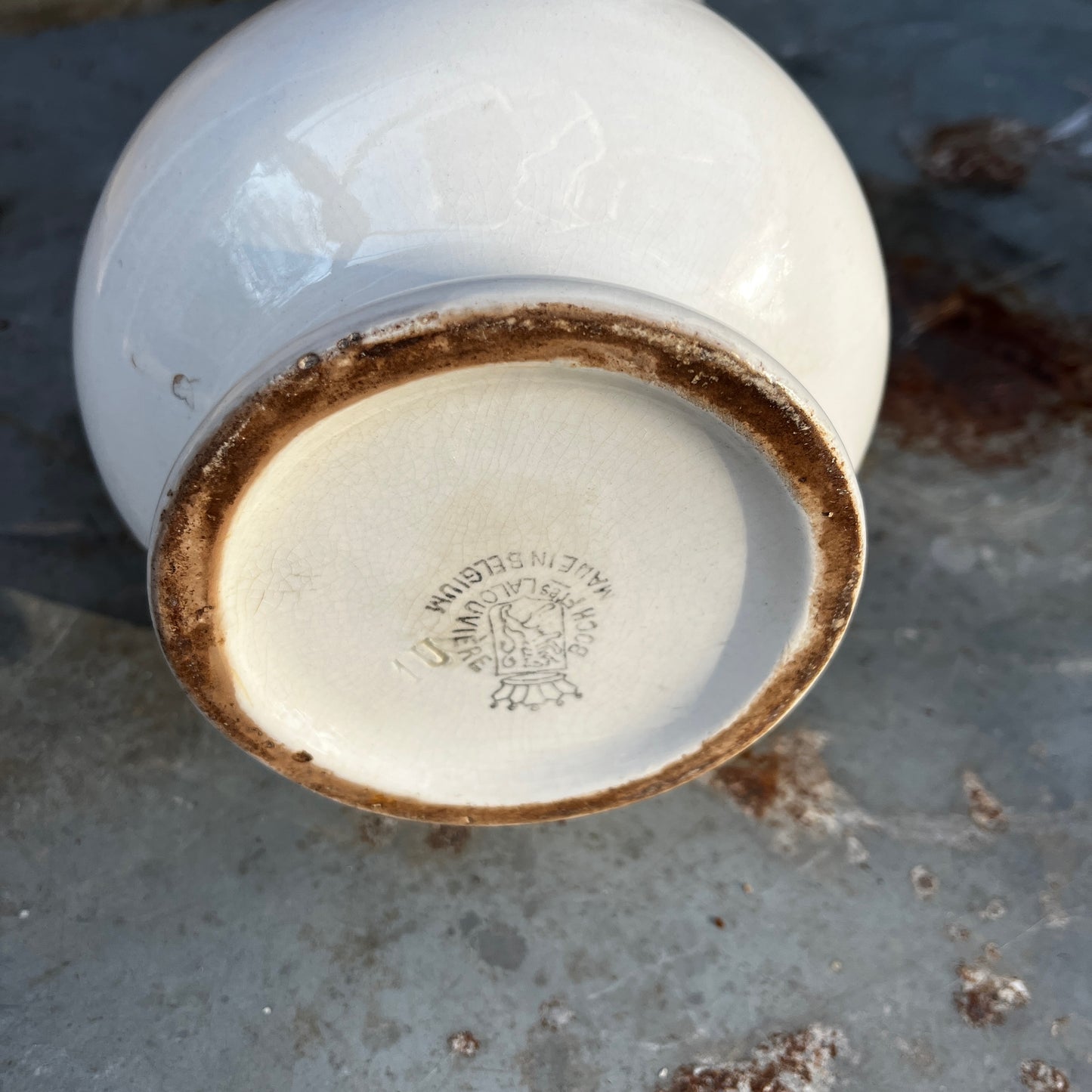 Simple French white ceramic jug with a elongated scalloped body, curved handle, and minimalist glazed finish in a classic utilitarian style.