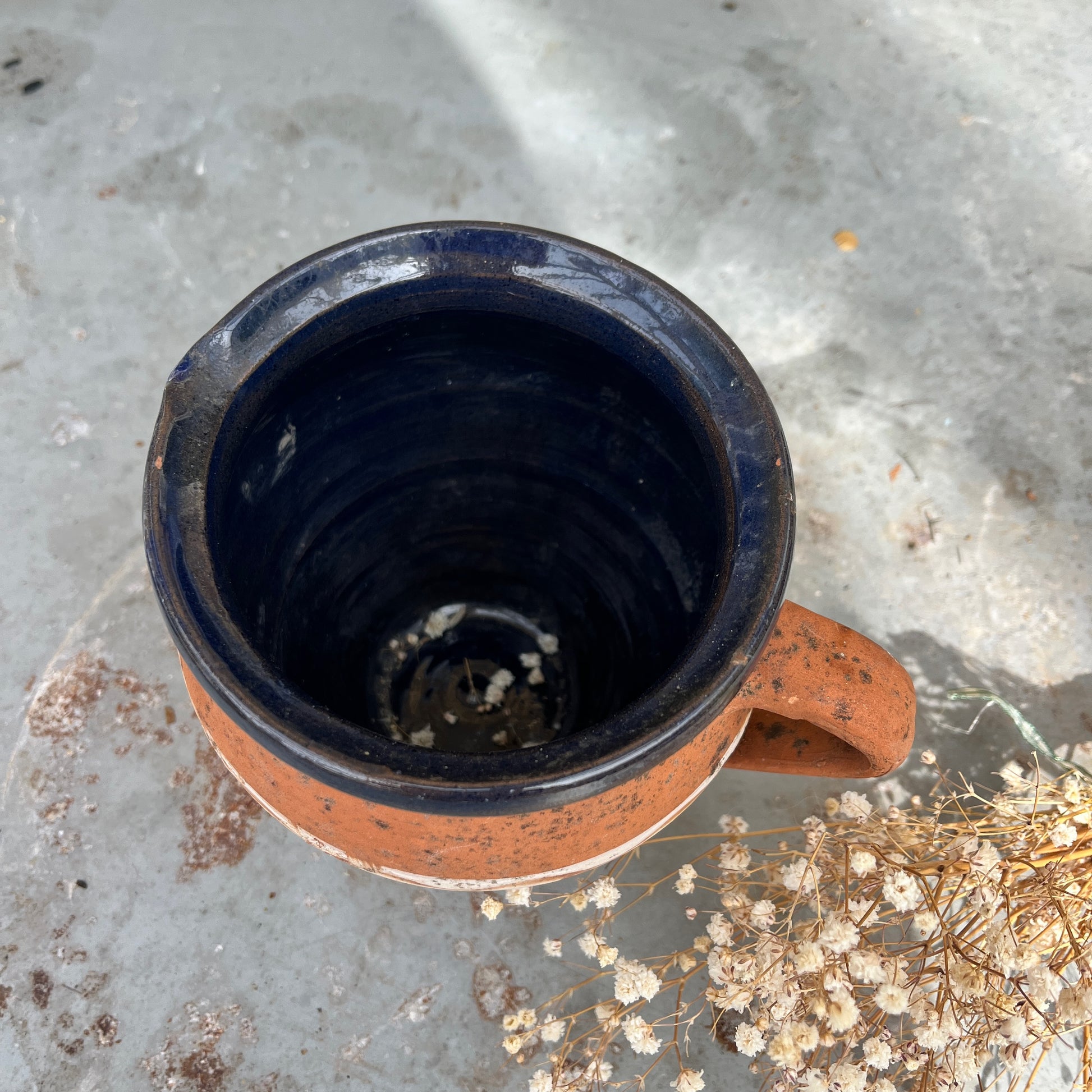 Rustic terracotta jug with a white painted band encircling the center, showcasing traditional craftsmanship.