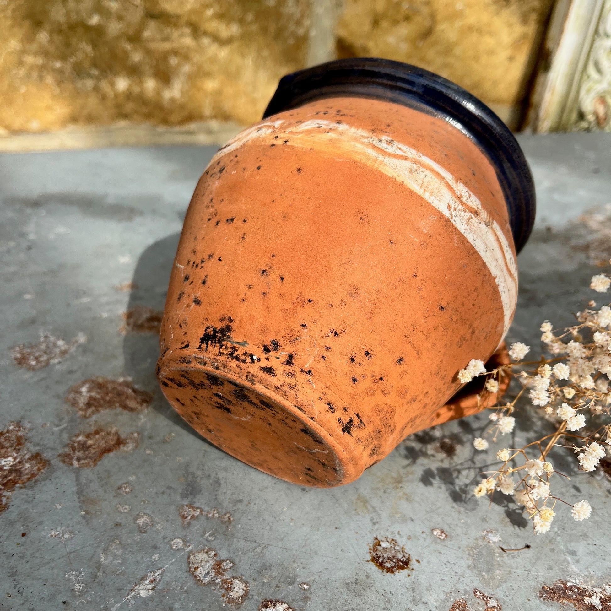 Rustic terracotta jug with a white painted band encircling the center, and black rim showcasing traditional craftsmanship.