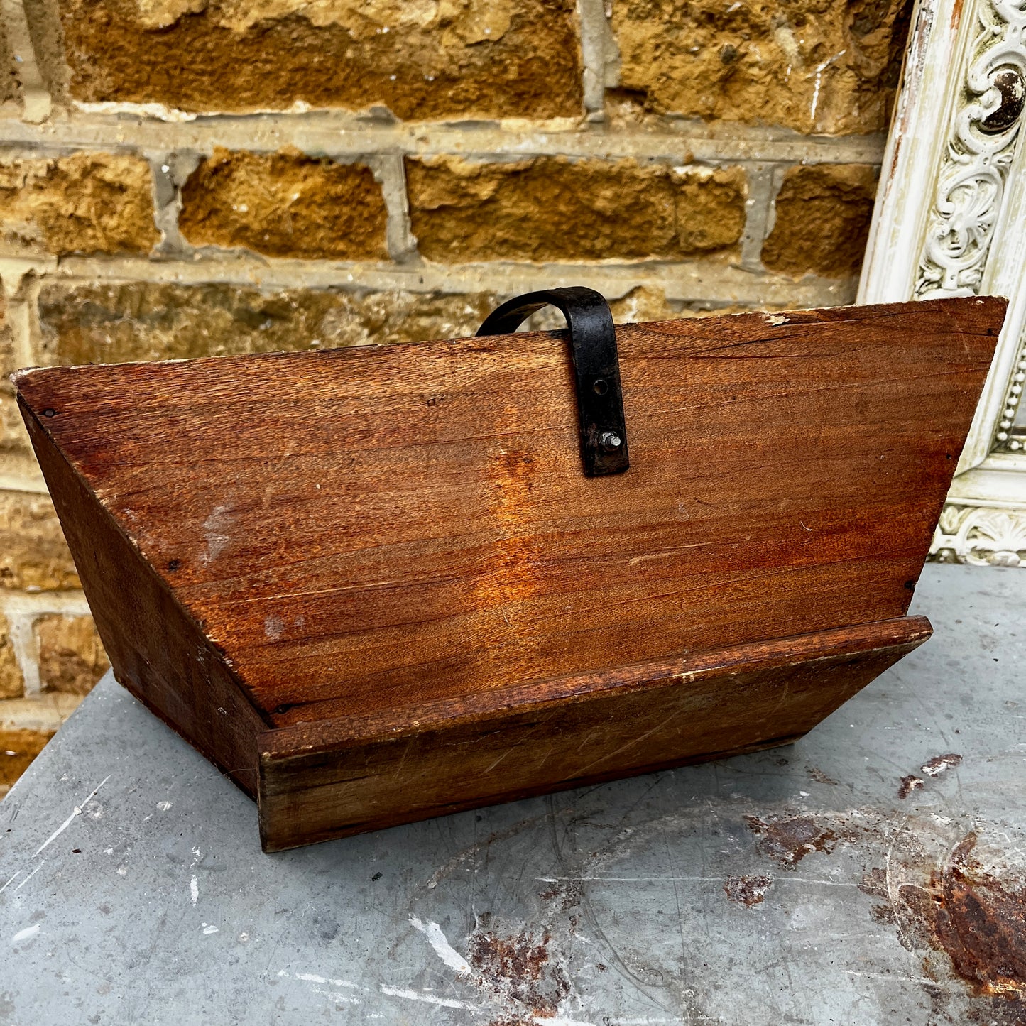 Rustic wooden trug with a black metal handle.