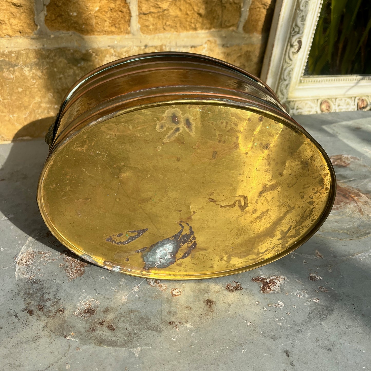 A vintage French copper planter with a glossy finish, featuring a delicate china handle adorned with a blue and white floral pattern.