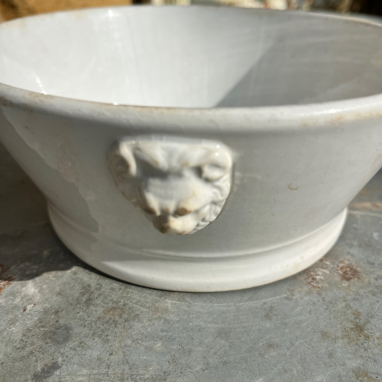 White vintage ceramic bowl with lion's head features