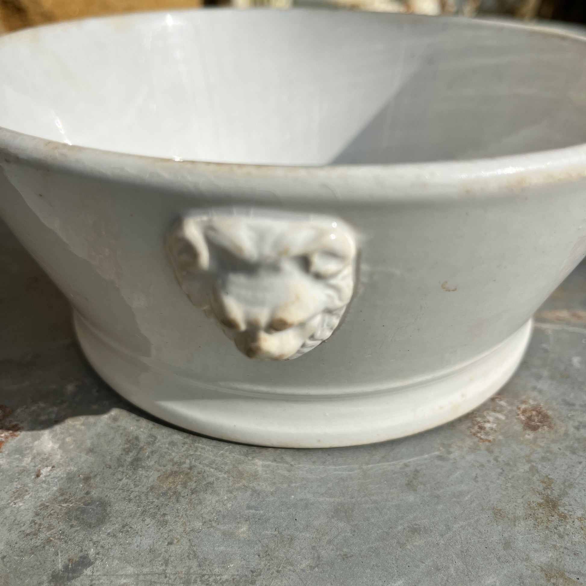 White vintage ceramic bowl with lion's head features
