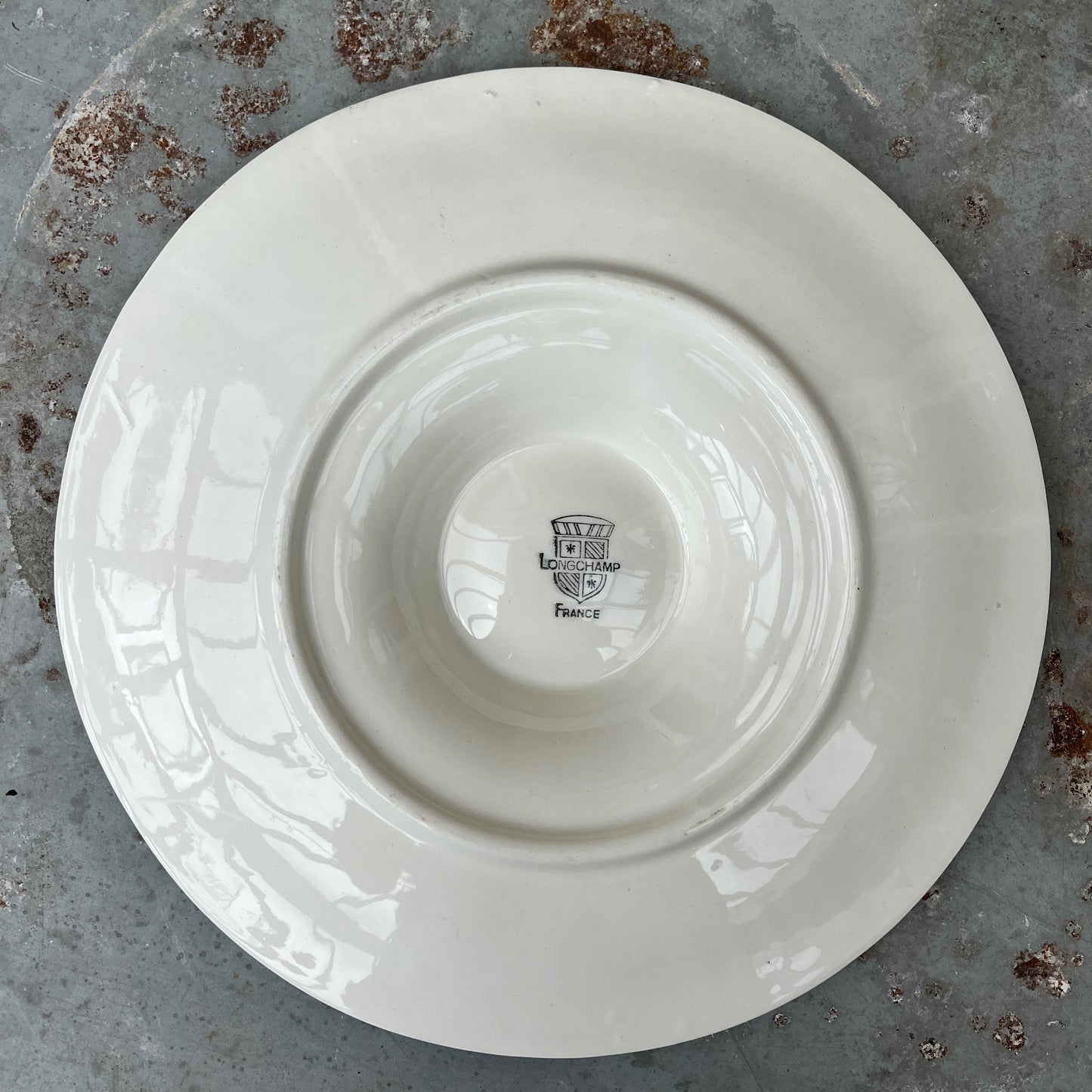 Vintage white ceramic oyster plate with shell design on a textured surface - French