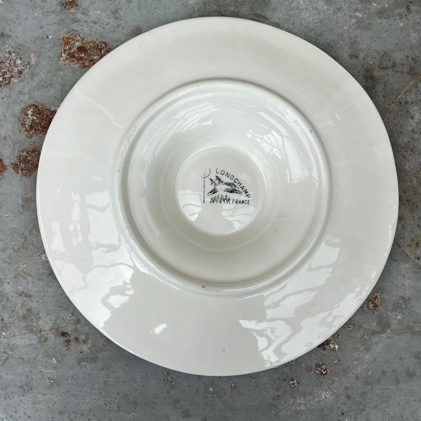 Vintage white ceramic oyster plate with shell design on a textured surface - French