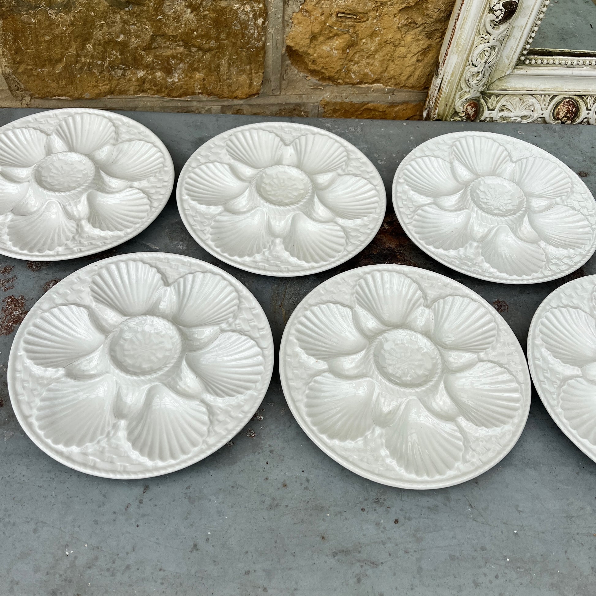 Vintage white ceramic oyster plate with shell design on a textured surface - French