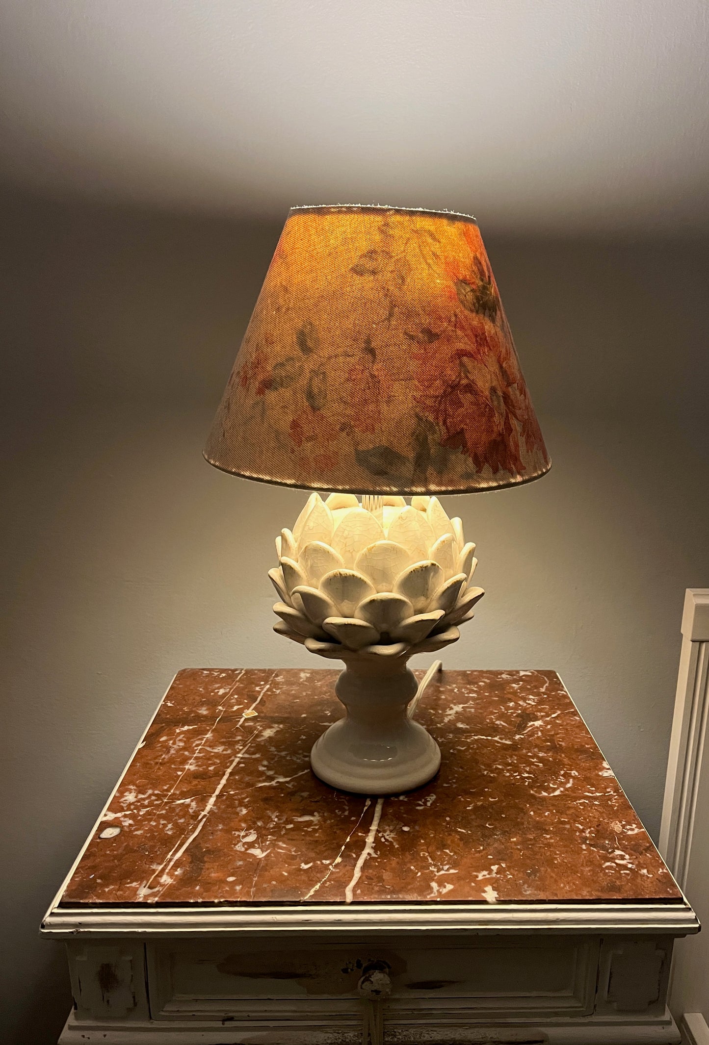 A pair of artichoke lamp bases hosting handmade shades made from a Cabbages & Roses style linen.