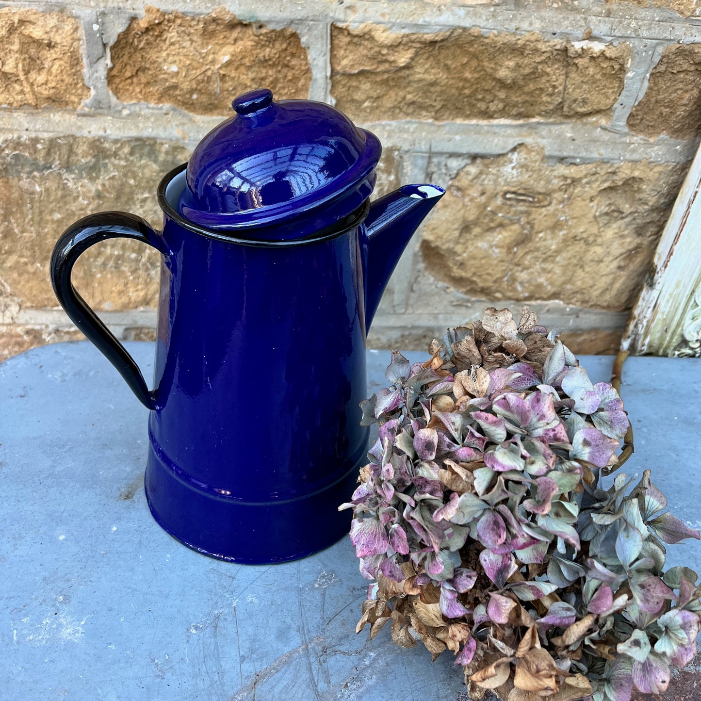 Vintage French dark blue enamel coffee pot with black handle and rim and separate lid.