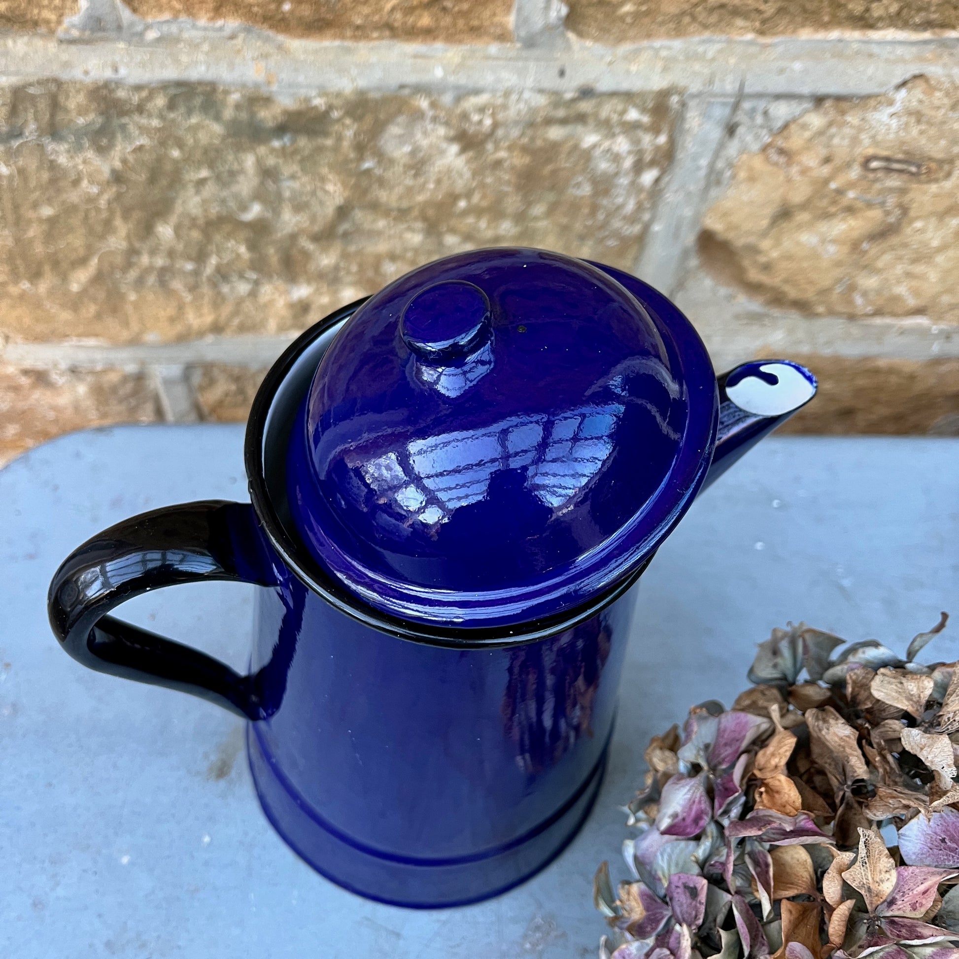Vintage French dark blue enamel coffee pot with black handle and rim and separate lid.