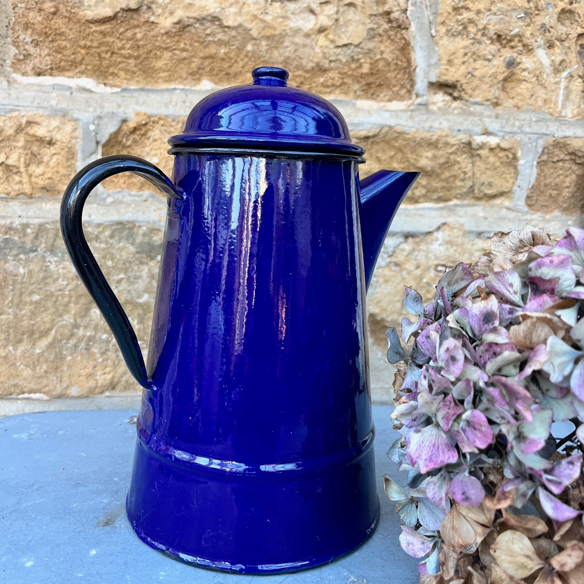 Vintage French dark blue enamel coffee pot with black handle and rim and separate lid.