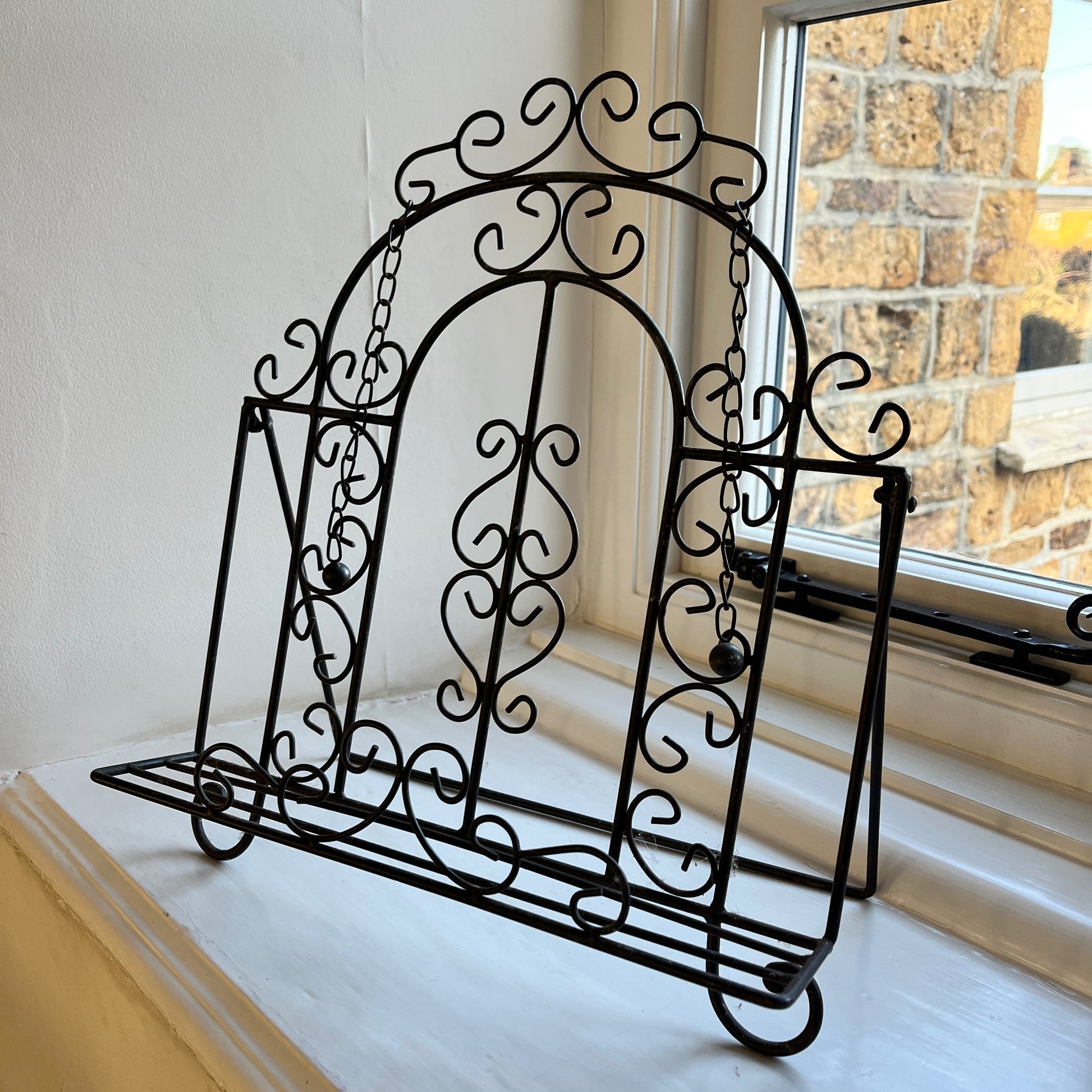 An intricantly designed wire book holder, featurning elegant patterns - perfect for holding a book