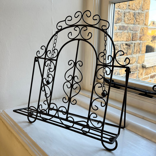 An intricantly designed wire book holder, featurning elegant patterns - perfect for holding a book