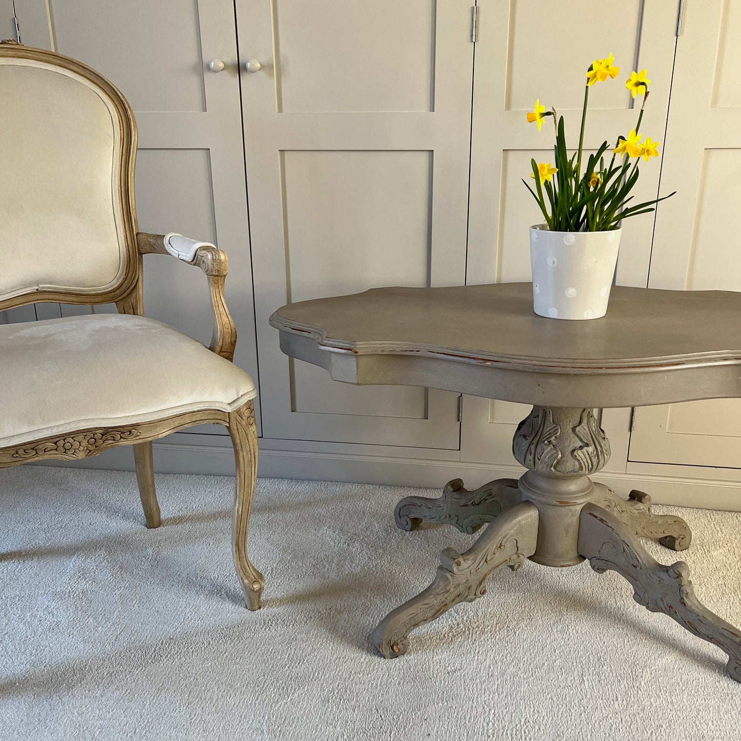 A classically elegant French vintage grey 'violin' shaped coffee table which has a central stem and four legs