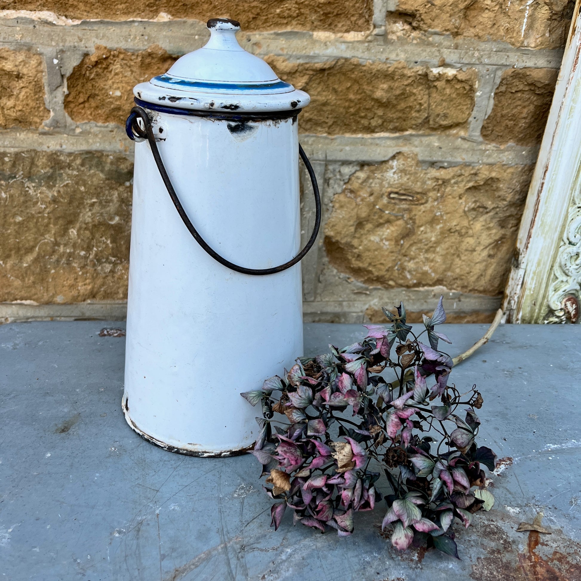 Vintage French milk churn in white with black handle and separate lid with blue detail