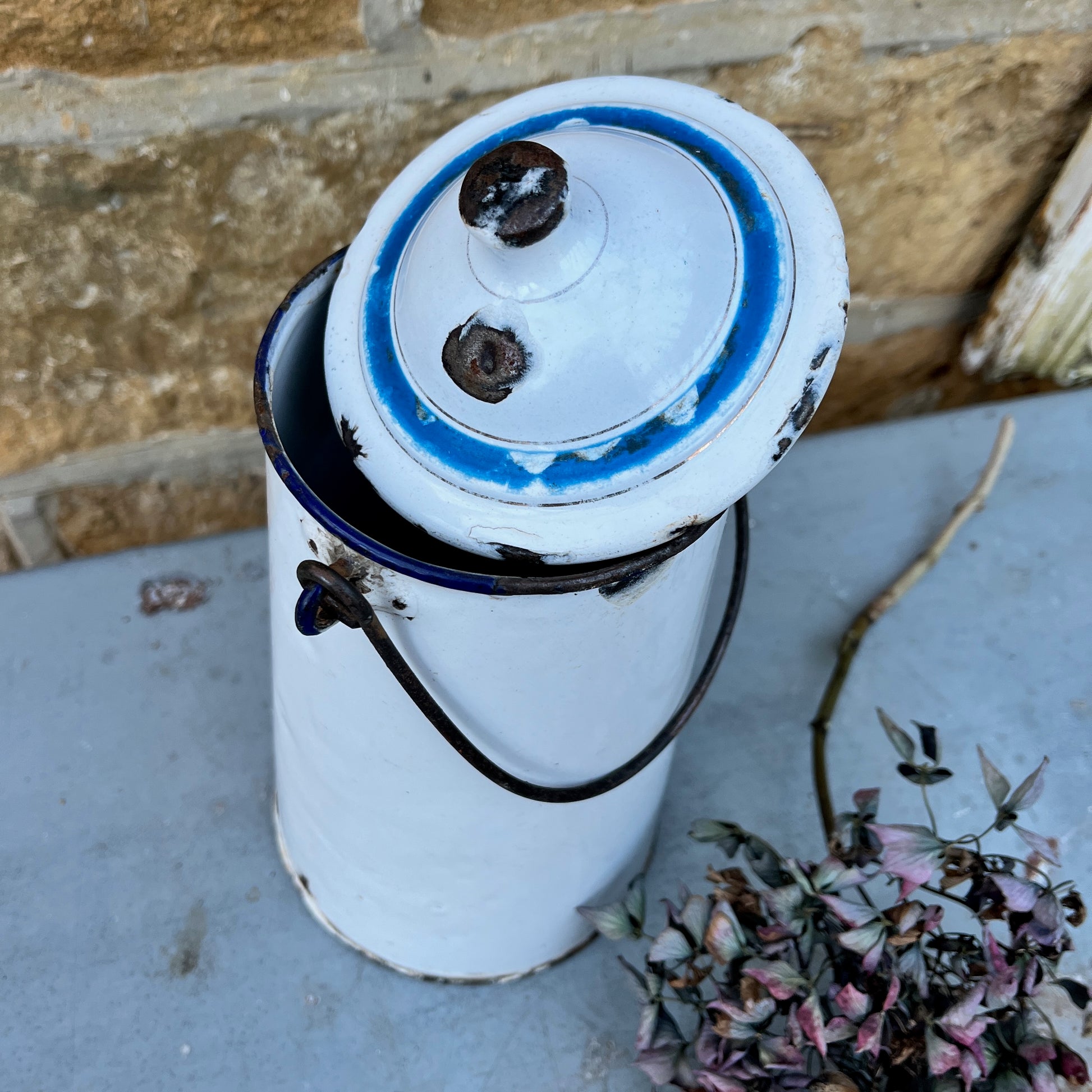 Vintage French milk churn in white with black handle and separate lid with blue detail