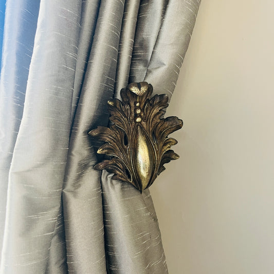 A pair of French antique ormolu tie backs from the 19th century, intricately crafted with gilded bronze, showcasing ornate floral and scroll designs, adding a touch of opulent elegance to vintage decor.