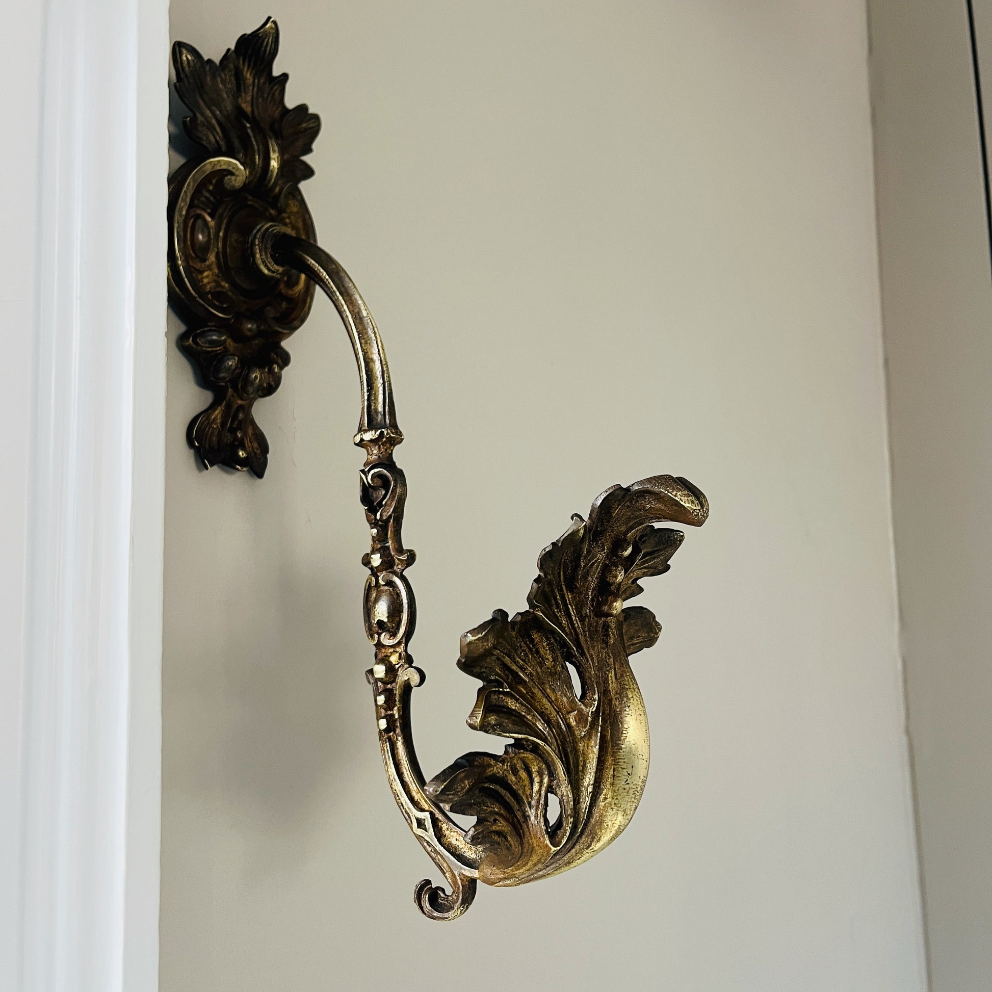 A pair of French antique ormolu tie backs from the 19th century, intricately crafted with gilded bronze, showcasing ornate floral and scroll designs, adding a touch of opulent elegance to vintage decor.