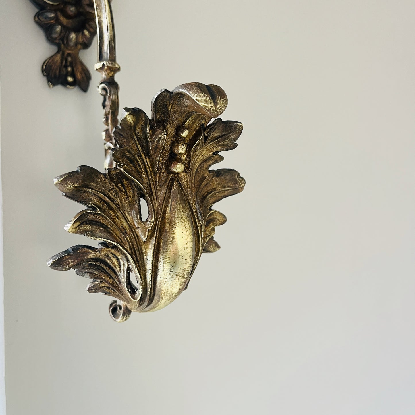 A pair of French antique ormolu tie backs from the 19th century, intricately crafted with gilded bronze, showcasing ornate floral and scroll designs, adding a touch of opulent elegance to vintage decor.